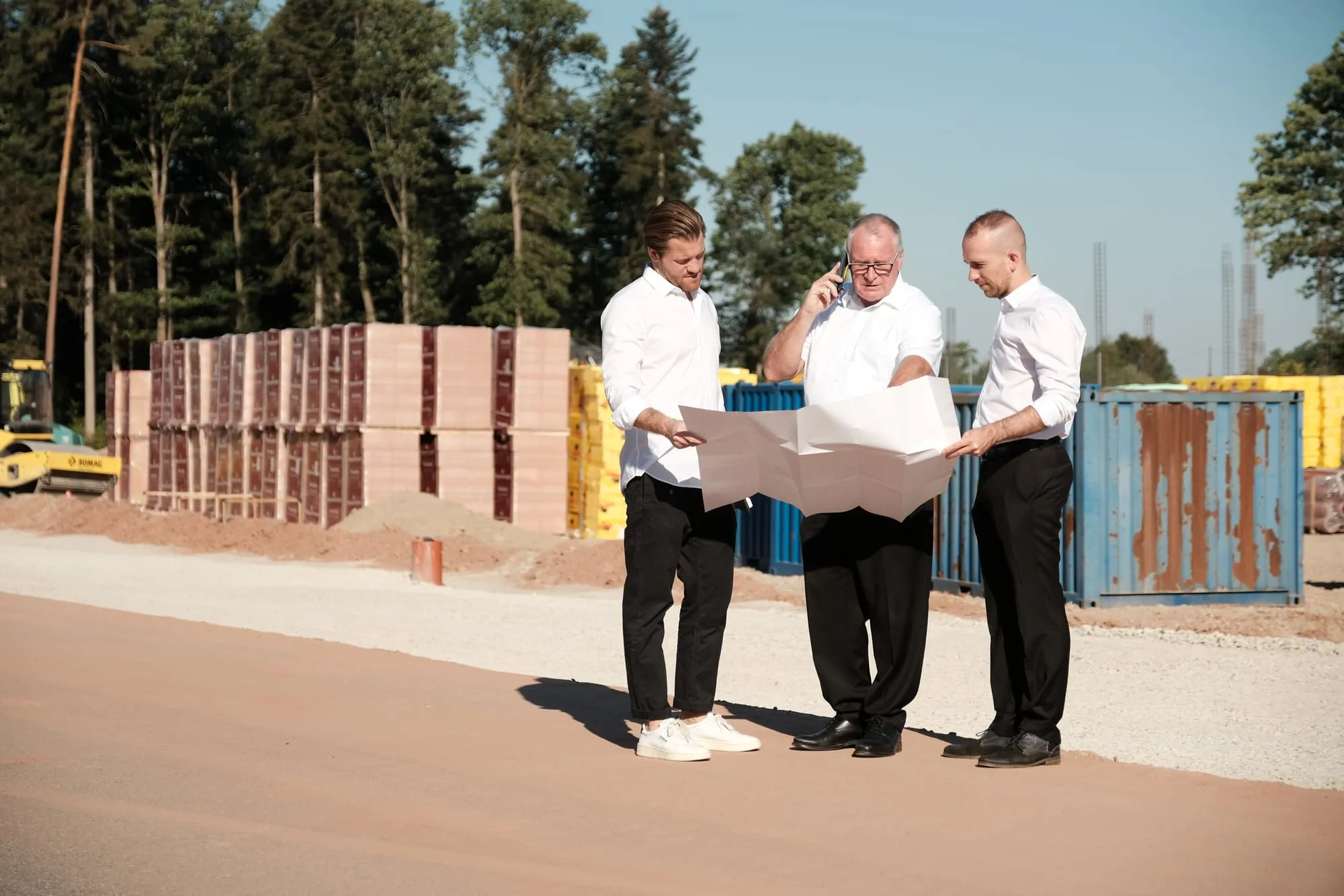 Drei Geschäftsführer von GEOTEAM besprechen Pläne auf einer Baustelle