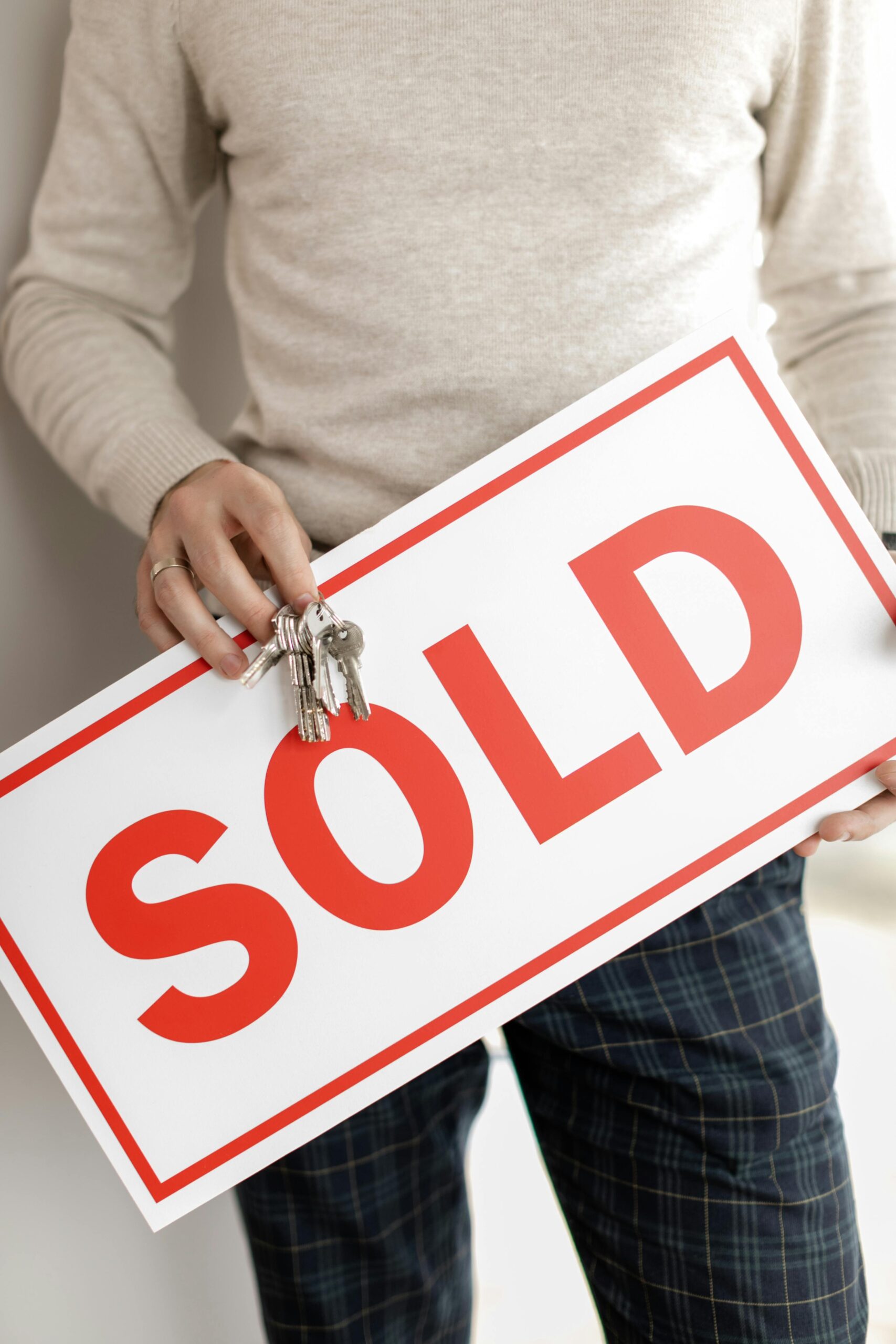 Haus verkauft - mann hält sold Schild